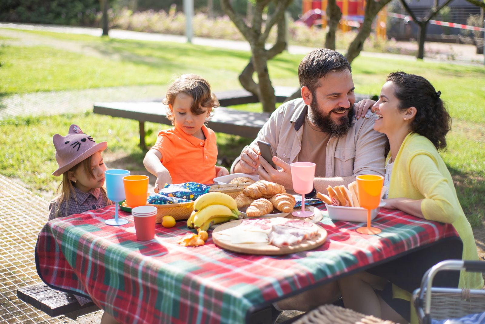 Parents and children sharing a picnic outdoors